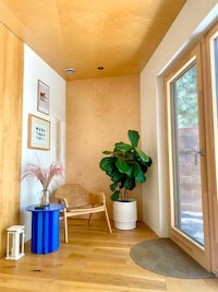 an entryway with a blue chair and a plant