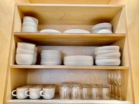 a wooden cabinet with plates and cups on it