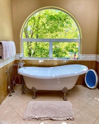 a bathroom with an arched window and a bathtub